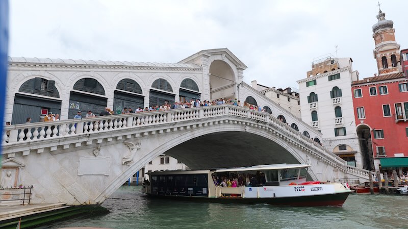 vendig-boot-faehrt-unter-rialtobruecke-her Ein Boot fährt unter der Rialtobrücke in Venedig hindurch.
