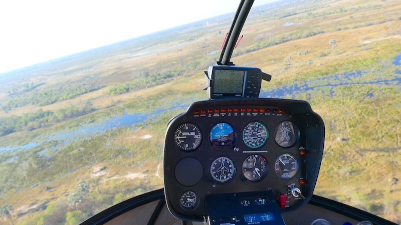 botswana-okavango-delta-rundflug-instrumente-und-landschaft Das Cockpit eines R44-Helis bei einem Flug über das Okavango-Delta.